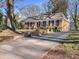 Brick ranch home with a large front yard, driveway, and mature trees at 3801 Champaign St, Charlotte, NC 28210