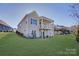 Well-maintained backyard of two-story home with covered porch, patio and lush lawn on a sunny day at 45528 Misty Bluff Dr, Charlotte, NC 28278