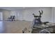 Home gym with a treadmill, elliptical machine, and lounge chairs with natural light streaming in from a window at 45528 Misty Bluff Dr, Charlotte, NC 28278