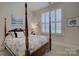 Charming bedroom with a four-poster bed and plantation shutters at 45528 Misty Bluff Dr, Charlotte, NC 28278