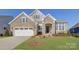 Attractive two-story home with stone exterior and a manicured lawn at 45528 Misty Bluff Dr, Charlotte, NC 28278