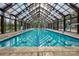 Indoor swimming pool with glass enclosure and pool deck at 45528 Misty Bluff Dr, Charlotte, NC 28278