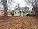 Large backyard with leaf covered lawn, showing a teal colored home in the background at 507 Park Ave, Salisbury, NC 28144