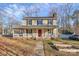 Two-story house with front porch, red door, and landscaped yard at 6558 Regatta Ln, Charlotte, NC 28227