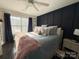 Bright bedroom with a plush bed, decorative pillows, and dark-blue accent wall at 8020 Long House Ln, Fort Mill, SC 29707