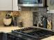 Modern kitchen detail showing cooktop, unique tile backsplash, and built-in shelving at 8020 Long House Ln, Fort Mill, SC 29707