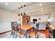 Open-concept dining room with a wooden table, stylish light fixtures, and exposed beam ceilings at 109 Chanticleer Ct, Charlotte, NC 28214
