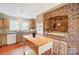 Well-lit kitchen with center island, wooden cabinetry, brick oven, and ample counter space at 109 Chanticleer Ct, Charlotte, NC 28214