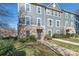 Three-story townhome with gray siding, brick accents, and a walkway at 1304 Queen Lyon Ct, Charlotte, NC 28205