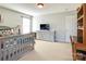 Bedroom with gray crib, dresser, and TV at 13836 Ballantyne Meadows Dr, Charlotte, NC 28277