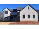 Modern farmhouse style home with board and batten siding, black trim, and a covered front porch at 13944 Roosevelt Grove Dr, Huntersville, NC 28078