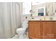 Clean bathroom with wood vanity, toilet and shower at 15210 Pangborn Pl, Charlotte, NC 28278