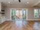 Bright living room with a walkout to a covered porch and hardwood floors at 18140 Kalabash Rd, Charlotte, NC 28278