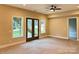 Spacious carpeted living room featuring a fan and views to the outdoor patio through glass doors at 18140 Kalabash Rd, Charlotte, NC 28278