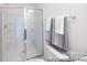 Bright bathroom featuring a glass enclosed shower, white tiling, and chrome hardware at 205 Cliffwood Nw St # B-2, Concord, NC 28027