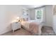 Serene bedroom with soft bedding, a nightstand, and a window, creating a restful retreat at 205 Cliffwood Nw St # B-2, Concord, NC 28027