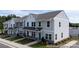 View of townhomes with manicured lawns, sidewalks, and convenient parking spaces at 205 Cliffwood Nw St # B-2, Concord, NC 28027