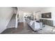Open-concept living room with hardwood floors, gray sofa, staircase, and view of kitchen at 205 Cliffwood Nw St # B-2, Concord, NC 28027