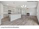 Open living room and kitchen area with a fireplace and grey wood-look floors at 2128 Clapham Ct, Charlotte, NC 28215