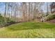 Spacious backyard with lush green grass and wooden stairs at 3504 Mountain Cove Dr, Charlotte, NC 28216