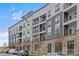 Modern apartment building with brick and gray siding, balconies, and ample parking at 3630 N Davidson St # 2210, Charlotte, NC 28205