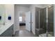 Bright bathroom features a double vanity, a walk-in shower and a view into the bedroom at 6420 Barcelona Way, Charlotte, NC 28214