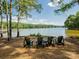 Four Adirondack chairs overlook a serene lake and tree-lined shore at 6420 Barcelona Way, Charlotte, NC 28214