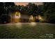 Ranch home with mature landscaping, brick walkway, and inviting nighttime ambiance at 825 W Ketchie St, China Grove, NC 28023