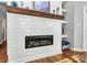 Modern fireplace with white brick surround and a wooden mantel at 921 Northeast Dr, Davidson, NC 28036