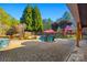 Inviting backyard pool with stone surround, patio, umbrella, and lounge chairs, perfect for outdoor relaxation and entertaining at 1024 Adkins Rd, York, SC 29745