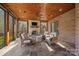 Covered porch with a wood burning fireplace, exposed brick and multiple seating areas at 1024 Adkins Rd, York, SC 29745