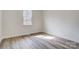 Neutral bedroom with wood-look floors, a window, and white trim at 122 Stockbridge Ln, Statesville, NC 28625