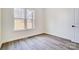 Bright empty bedroom with a view, wood-look flooring, and white trim at 122 Stockbridge Ln, Statesville, NC 28625