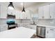 Modern kitchen featuring white cabinets, stainless steel appliances, quartz countertops, and stylish pendant lighting at 122 Stockbridge Ln, Statesville, NC 28625
