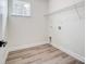 Clean laundry room with wood-look floors, bright walls, a window, and easily accessible hookups at 122 Stockbridge Ln, Statesville, NC 28625