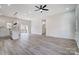 Spacious living room featuring light wood floors, a ceiling fan, and modern light fixtures at 122 Stockbridge Ln, Statesville, NC 28625