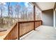 Back porch with stained wood railing, concrete flooring, and a peaceful wooded view at 122 Stockbridge Ln, Statesville, NC 28625
