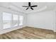 Spacious bedroom with light wood laminate flooring, neutral walls and three windows with blinds at 2442 Royal York Ave, Charlotte, NC 28210