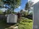 Grassy backyard featuring a shed with lawn and trees and a partial privacy fence at 2824 N Brevard St, Charlotte, NC 28205