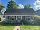 Charming single story home with a covered porch, well-maintained lawn, and blooming azalea bushes at 2824 N Brevard St, Charlotte, NC 28205