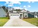 Two-story home with white and stone exterior and a two-car garage at 4003 Grace Pointe Dr # 99, Wesley Chapel, NC 28079