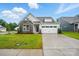 Charming home with stone accents, white siding, a well-manicured lawn, and a two-car garage at 4003 Grace Pointe Dr # 99, Wesley Chapel, NC 28079
