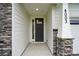 The home's front entrance is framed by stone pillars and white siding, providing a stylish and welcoming facade at 4003 Grace Pointe Dr # 99, Wesley Chapel, NC 28079