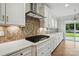 Modern kitchen with stainless steel appliances, white cabinets, light countertops, and a unique backsplash at 4003 Grace Pointe Dr # 99, Wesley Chapel, NC 28079