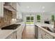 Bright, modern kitchen features white cabinets, stainless appliances, stone backsplash, and a gas cooktop at 4003 Grace Pointe Dr # 99, Wesley Chapel, NC 28079