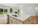 Modern kitchen island and sink are featured with a view of the fireplace and backyard through sliding glass doors at 4003 Grace Pointe Dr # 99, Wesley Chapel, NC 28079