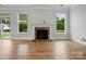 Cozy living room with a stone fireplace, hardwood floors, and sliding glass doors to the exterior at 4003 Grace Pointe Dr # 99, Wesley Chapel, NC 28079