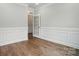 Living room with laminate floors, window and traditional wainscotting at 4003 Grace Pointe Dr # 99, Wesley Chapel, NC 28079