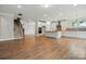 Open floor plan with a modern kitchen island, stainless hood, and staircase in the background at 4003 Grace Pointe Dr # 99, Wesley Chapel, NC 28079