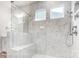 Spa-like shower with marble tile, built-in seat, and glass enclosure at 4003 Grace Pointe Dr # 99, Wesley Chapel, NC 28079
